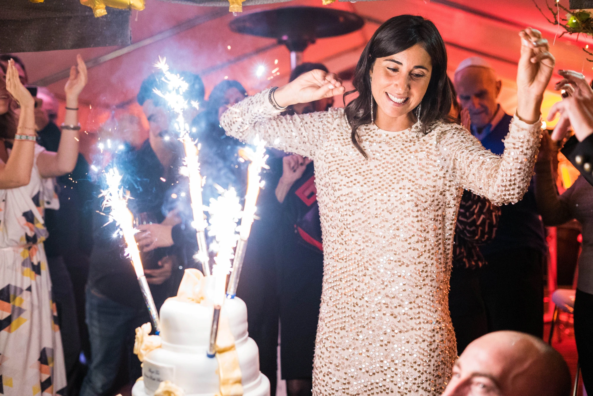 Femme dansant près d'un gâteau avec étincelles